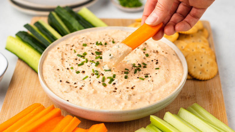 dipping carrot into deviled egg dip