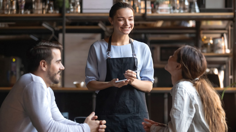 Server take couple's order at restaurant