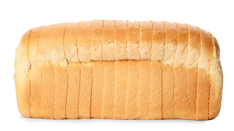 A full loaf of sliced white bread on white background