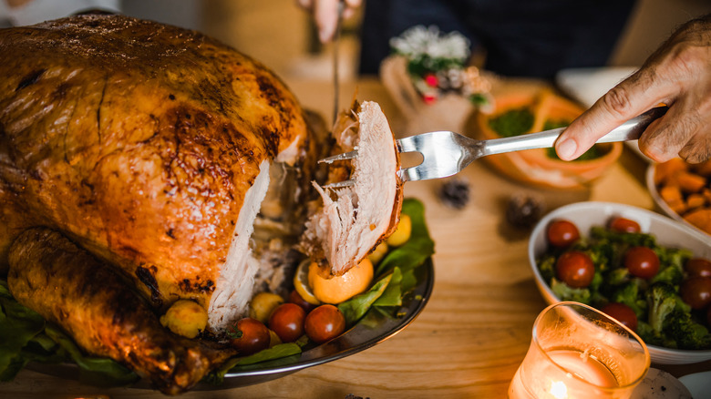 person carving Thanksgiving turkey