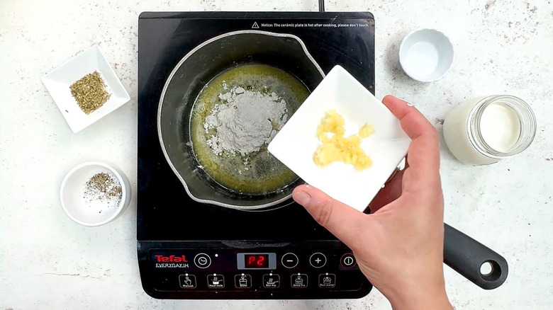 adding garlic to saucepan