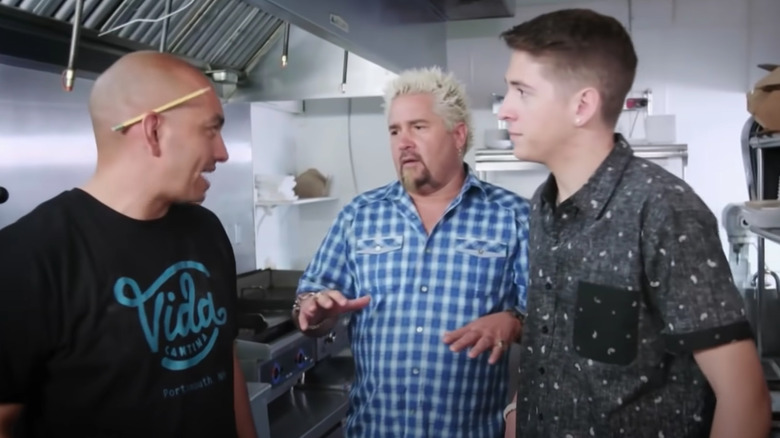 Guy, Hunter and chef talking in kitchen