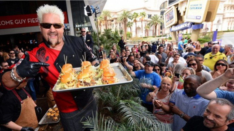 Guy holding burgers at his restaurant