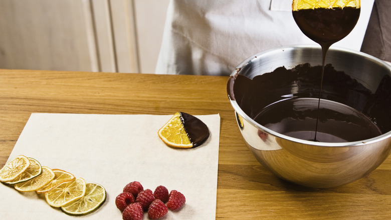 Candied fruit being dipped in chocolate