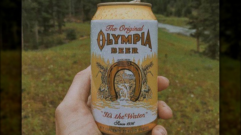 hand holding olympia beer can