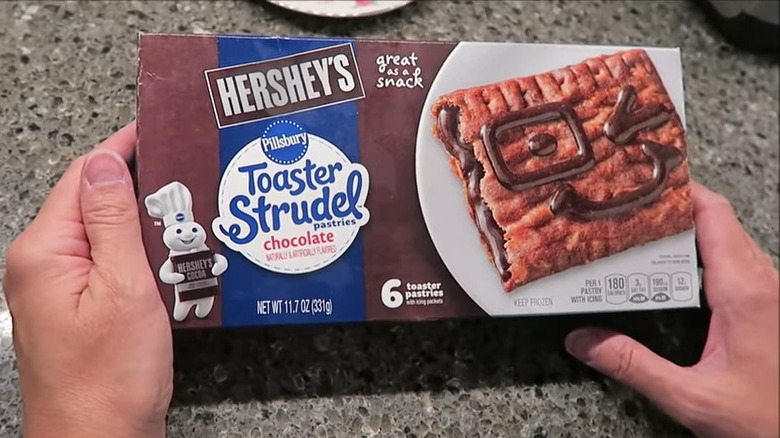 Hands holding box of Hershey's Toaster Strudel 