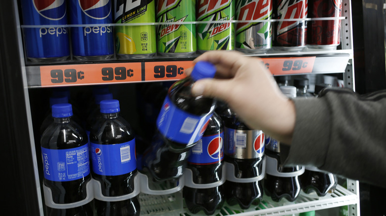 Person buying Pepsi at convenience store