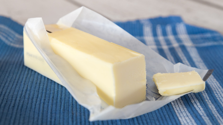 Stick of butter in opened wrapper on table