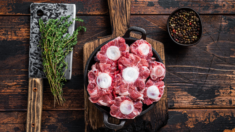 Oxtail in a pan on top of a cutting board