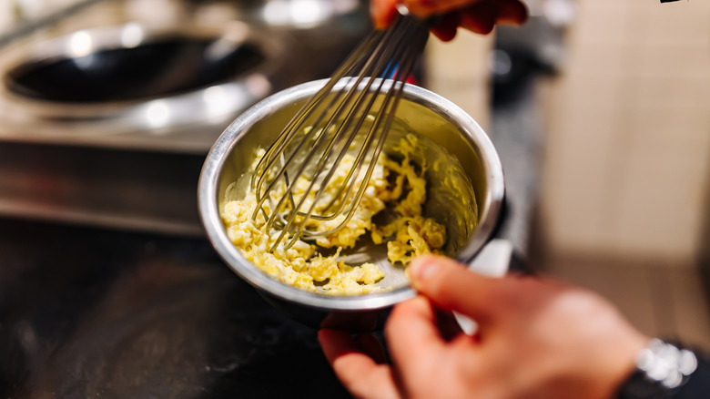 person whisking eggs in bowl