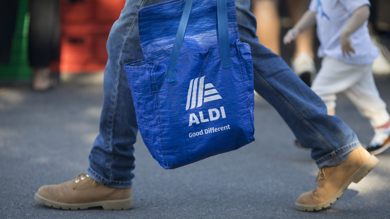 Person carrying Aldi reusable bag