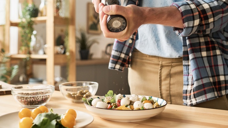 Man using pepper shaker