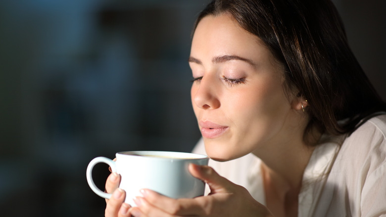 Woman blowing on hot drink