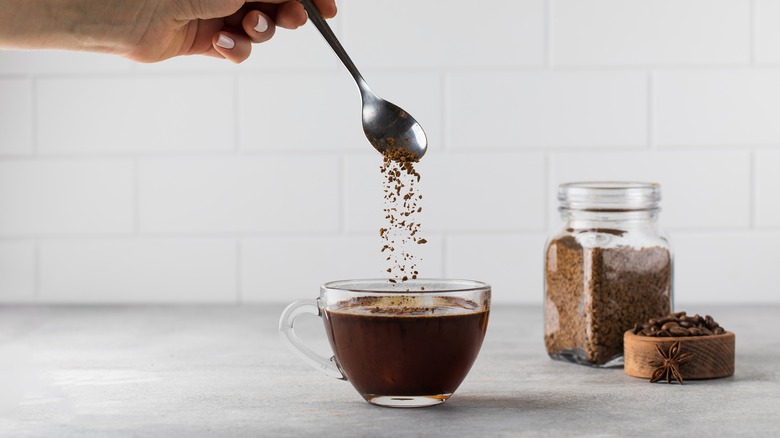 Instant coffee grains poured into cup