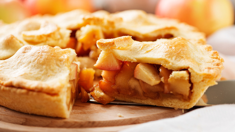 Homemade apple pie sliced on wooden surface