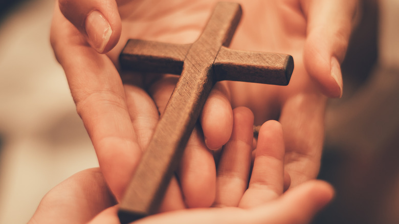 Hands holding religious cross