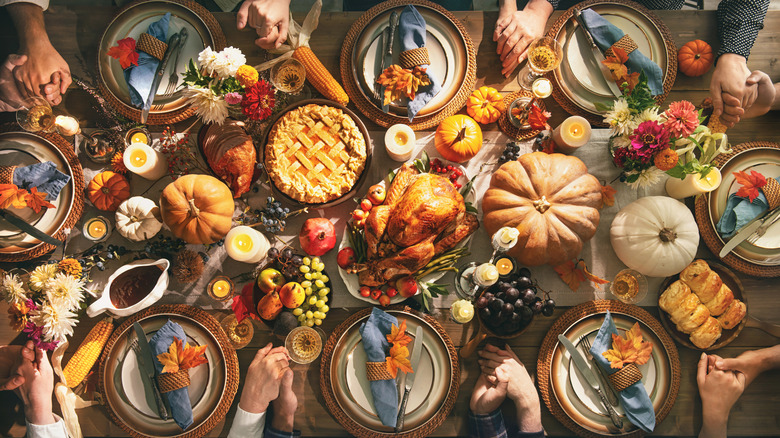 People holding hands around dinner table