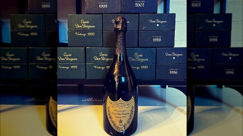 A bottle of Dom Perignon in front of boxes