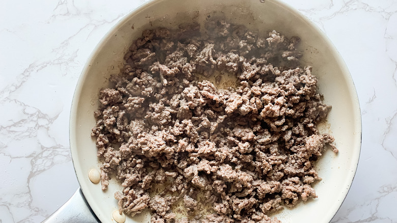 Ground beef cooked in a pan for Domino's Cheeseburger Pizza copycat recipe