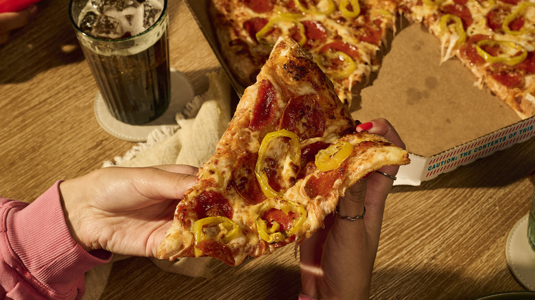 Person folding a slice of pizza