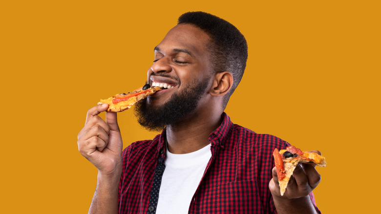 man eating thin crust pizza