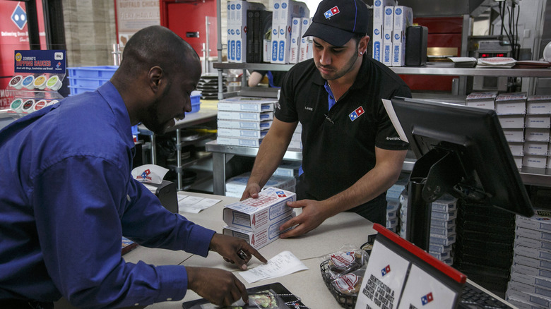 Domino's employee ringing up customer