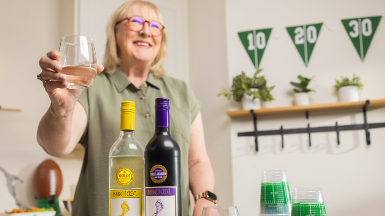 Donna Kelce holding glass of Barefoot wine