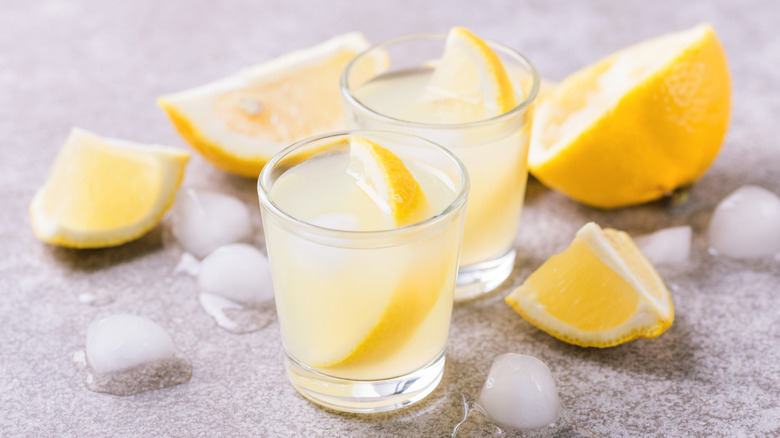 Two lemon drop shots with lemon slices and ice