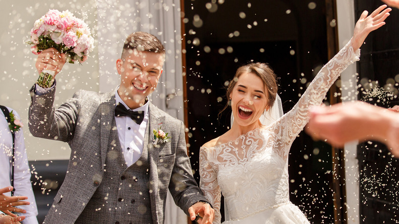 guests throw rice at couple getting married