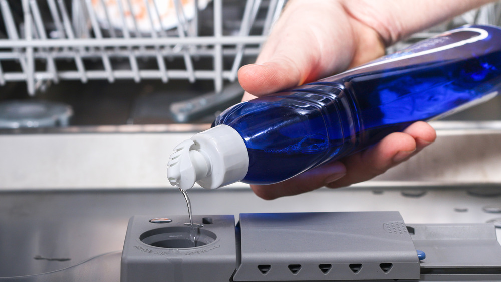 pouring rinse aid into the dishwasher