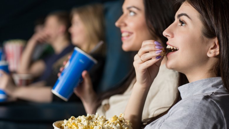 Women at movies eating popcorn