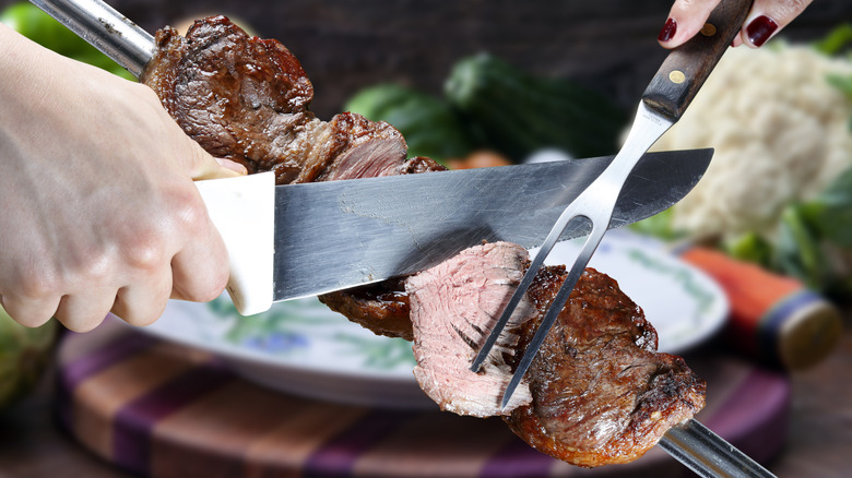 person slicing picanha