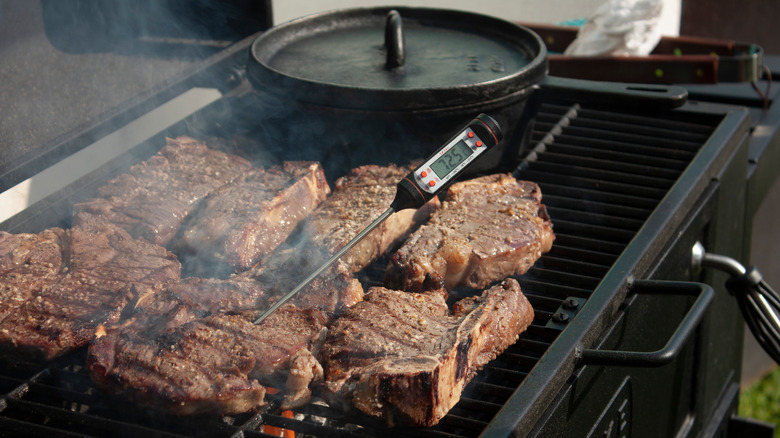 Meat thermometer and meat on grill