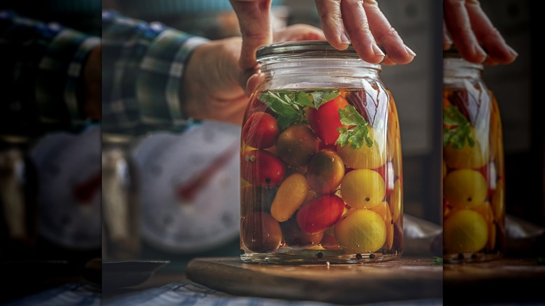 Person jarring pickled tomatoes