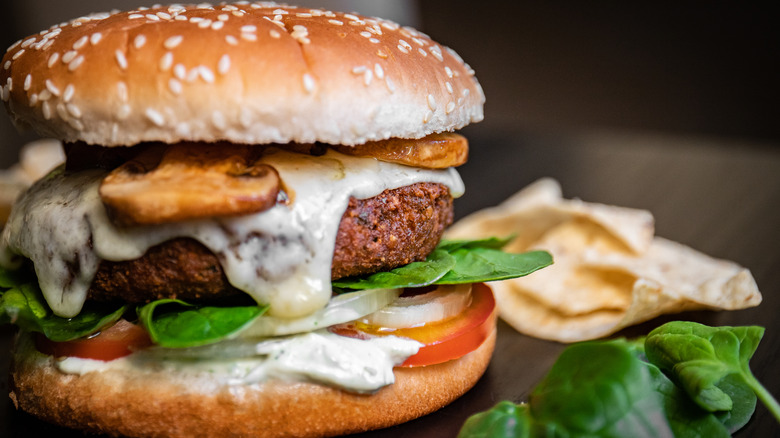 Falafel burger with tomato, spinach, and mushroom on bun