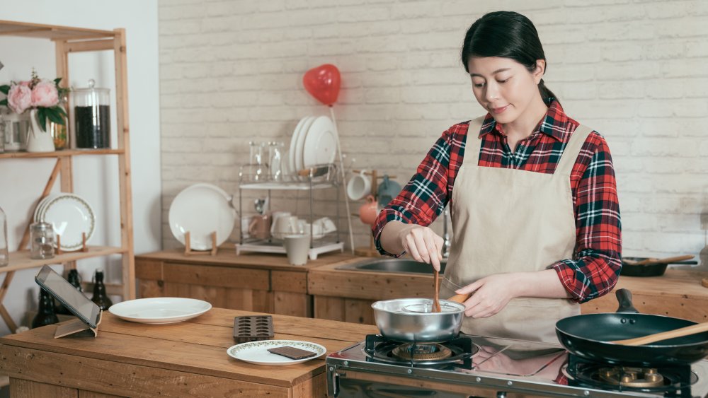 woman melting sugar on stove top