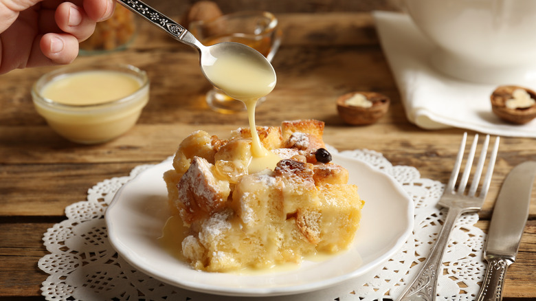 Bread pudding on plate drizzled with custard