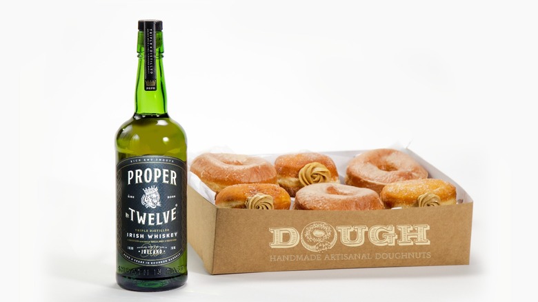 Whiskey bottle and Irish coffee next to boozy donuts