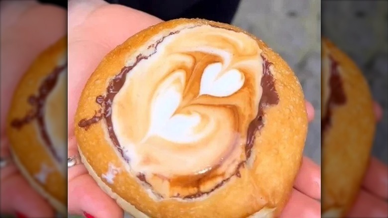 Hand holding a coffee filled donut