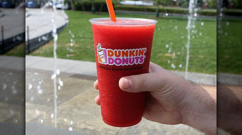 Person holding cold red drink