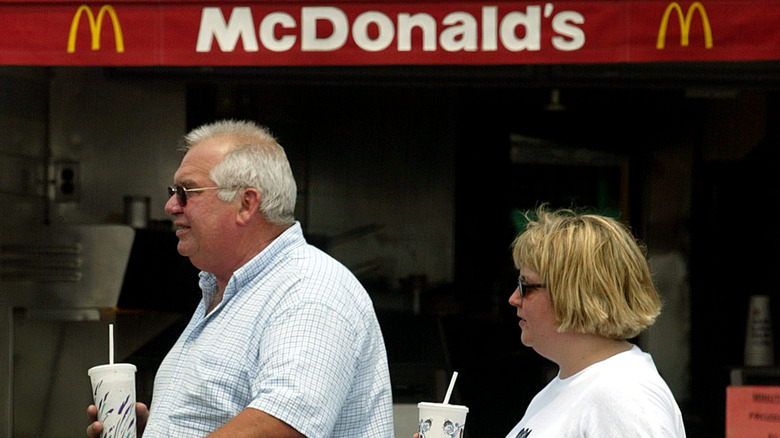 Pair of people walking outside McDonald's