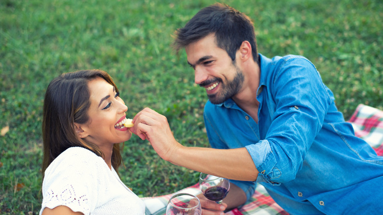 couple eating cheese with wine