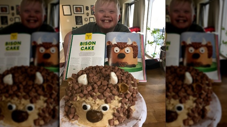 Boy smiling with book and bison cake