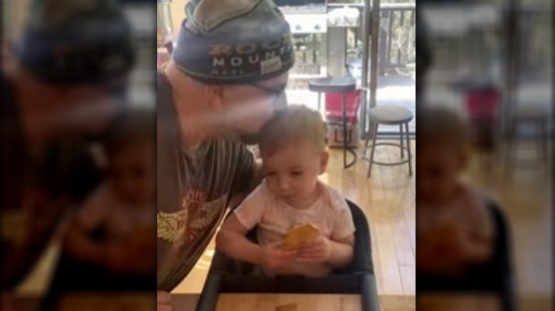 Duff Goldman kissing his daughter's head as she eats a cookie