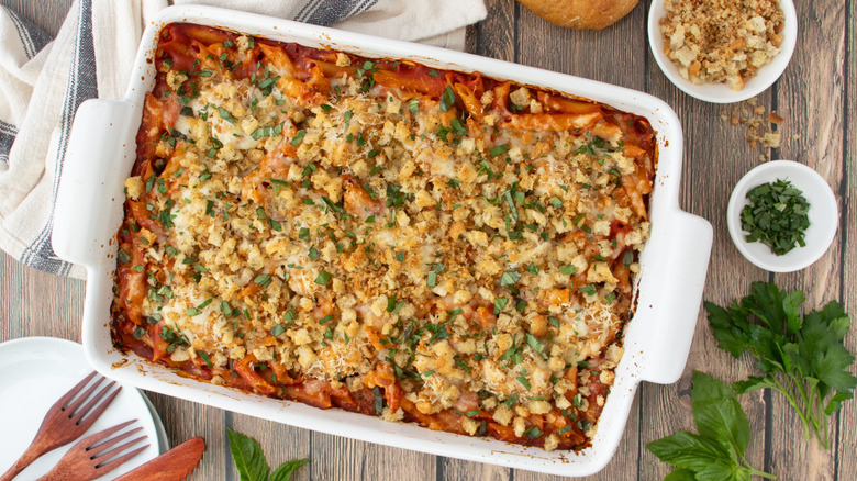 pasta casserole in a pan on a striped dishtowel