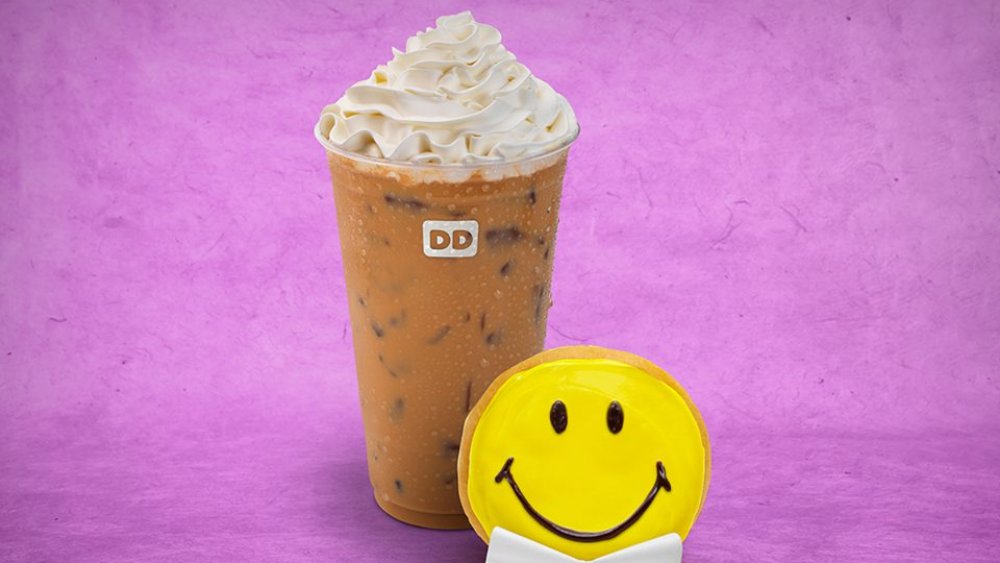 Dunkin' Donuts iced coffee with shipped cream and a smiley face cookie
