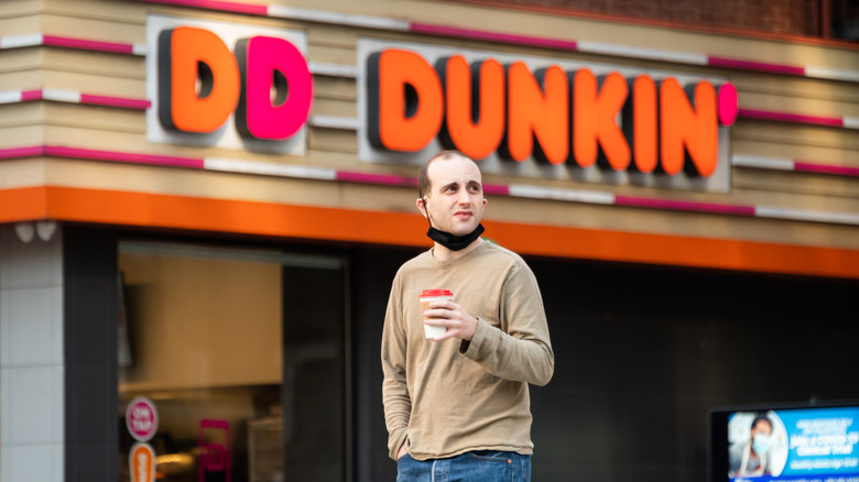 A person walking outside of a Dunkin'