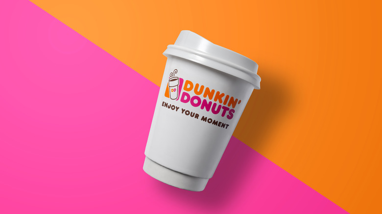 Dunkin' Donuts cup on pink and orange background