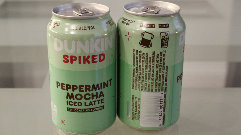 A front and back view of two cans of Dunkin' spiked lattes.