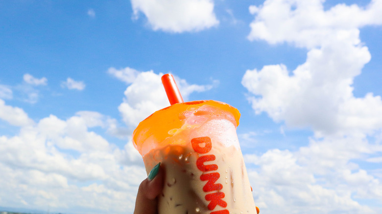 hand holding Dunkin' Iced Coffee